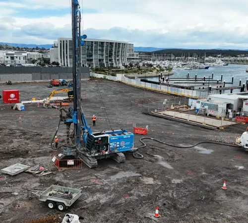 Design and construct piling Shell Cove: SR-45 rig drilling a CFA pile beside a concrete pump and truck near the marina